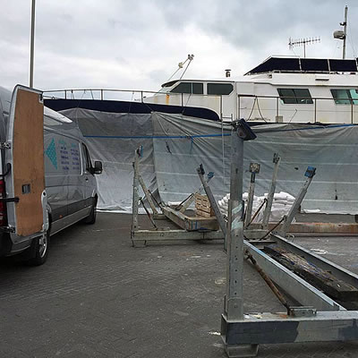 Boat wrapped in protective sheeting ready for sand blasting or shot blasting